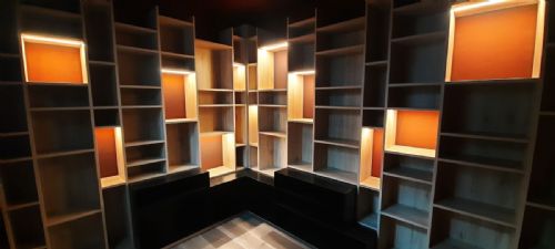 Scaffalatura su misura con nicchie retroilluminate arancioni, cantina privata a Bollate, Milano — Winest