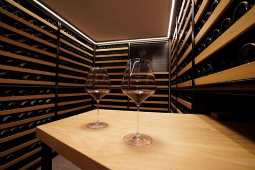 Cantina vini da collezione con scaffali in rovere e tavolo degustazione, Livorno, Toscana — Winest