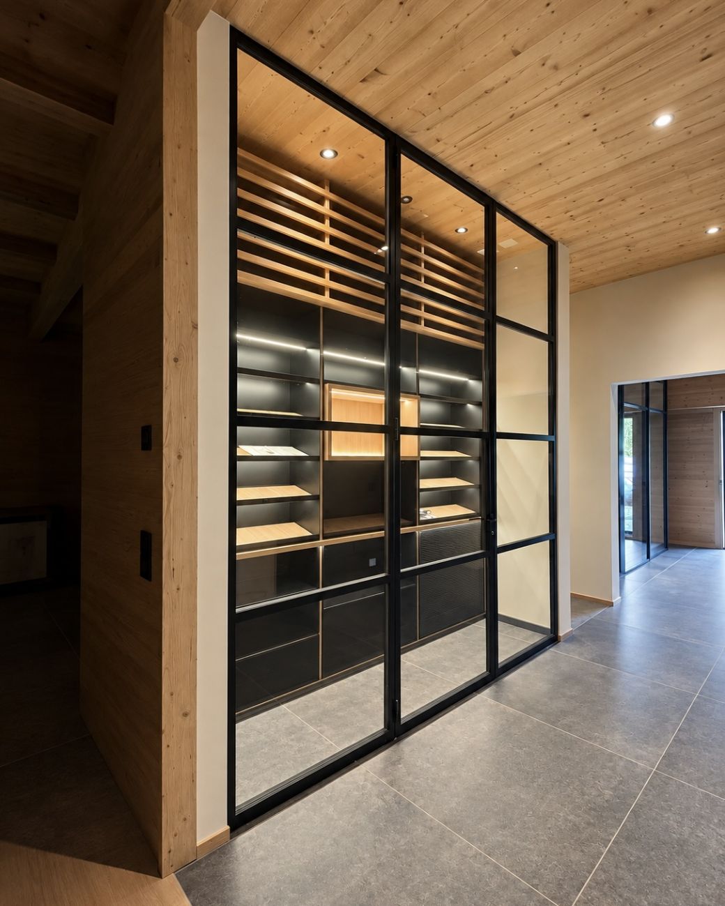 Cantina vini su misura a Crans-Montana: wine room in larice e rovere, ispirata allo chalet alpino, con LED integrato. Un progetto Winest.